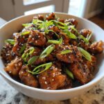 A bowl of delicious Air Fryer Teriyaki Chicken, garnished with sesame seeds and green onions.