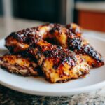 Close-up of Balsamic Baked Chicken Breast pieces on a white plate, showing the glaze.
