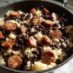 Close-up of Black Beans and Rice Sausage in a skillet, featuring sliced sausage, rice, and black beans.
