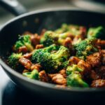 Close-up of Chicken Broccoli Skillet in a dark pan, showcasing the chicken and bright green broccoli.