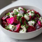A vibrant bowl of Chickpea Beet Feta Salad with Lemon-Garlic dressing, topped with fresh parsley.