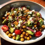 A vibrant bowl of Chickpea Feta Avocado Salad with tomatoes, red onion, and a light dressing.