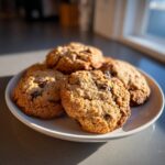 A plate of freshly baked Chocolate-Peanut Butter Cookies, golden brown with visible chocolate chunks.