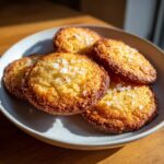 A plate of golden brown French Salted Butter Cookies, sprinkled with coarse sea salt.