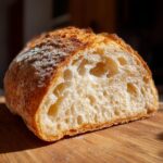 Close-up of a slice of A Fresh Italian Bread showing the crust and airy interior texture.
