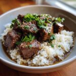 A bowl of Garlic Butter Beef and Rice, garnished with fresh parsley.