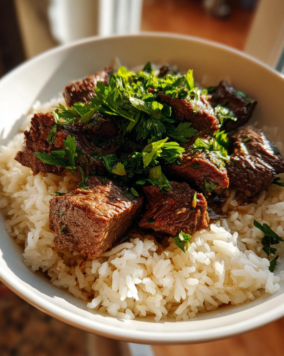 A delicious bowl of Garlic Butter Beef and Rice, garnished with fresh parsley.
