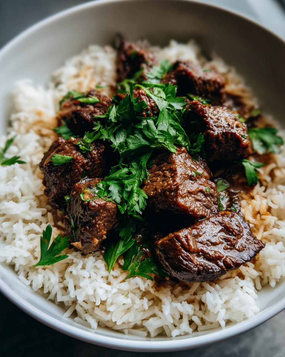 A delicious bowl of Garlic Butter Beef and Rice, garnished with fresh parsley.