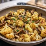 Close-up of a Garlic Cauliflower Mushroom Skillet, showing roasted cauliflower and mushrooms, garnished with herbs.