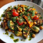 A vibrant Grilled Zucchini Chickpea Salad with grilled zucchini, chickpeas, tomatoes, and herbs on a white plate.