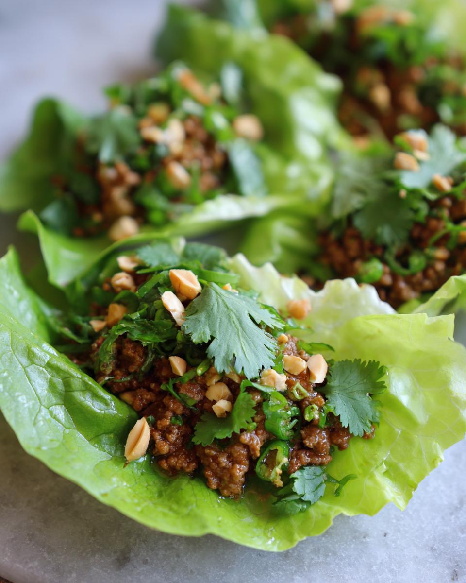 Close-up of Ground Beef Lettuce Wraps topped with cilantro and peanuts.