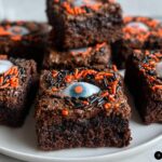 Delicious Halloween brownies decorated with candy eyeballs and orange and black sprinkles.