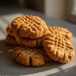A stack of freshly baked Homemade Copycat Nutter Butters cookies, golden brown and textured.