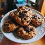 A plate of freshly baked Keto Flourless Fudge Cookies with melted chocolate chips on top.