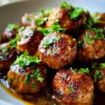 Close-up of Keto Garlic Butter Meatballs in a bowl, garnished with fresh parsley.