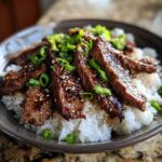 A delicious bowl of Korean BBQ Steak Rice topped with sesame seeds and fresh green onions.