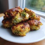A stack of Nutritious Chicken Broccoli Nuggets on a white plate, showcasing the chicken and broccoli texture.