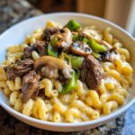 Bowl of Philly Cheesesteak Mac & Cheese with beef, peppers, and mushrooms.