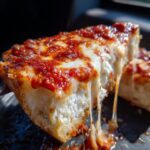 A close-up of a slice of Pizza Cottage Cheese Bake with melted cheese and tomato sauce.