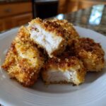 Close-up of Ranch-Crusted Chicken Bites on a white plate, showing the crispy coating and juicy chicken inside.