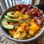 A delicious Savory Keto Breakfast Bowl with cheesy grits, crispy bacon, and fresh avocado slices.