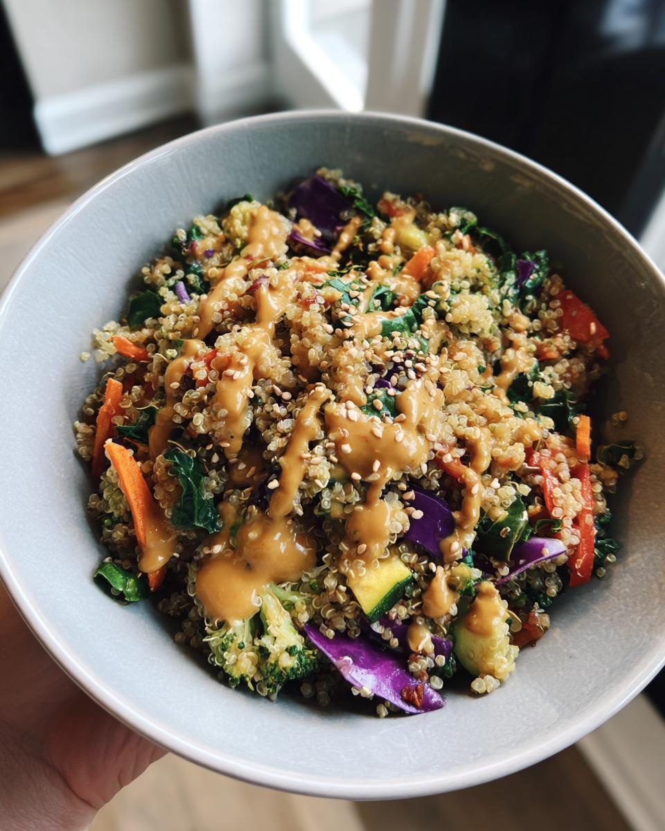 A colorful bowl of Thai Quinoa Salad with Peanut Dressing, featuring quinoa, vegetables, and a creamy peanut sauce.