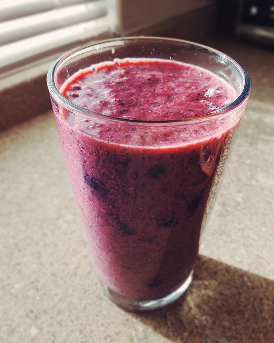 A vibrant berry breakfast smoothie in a glass, perfect for a quick and healthy breakfast.