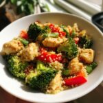 Bowl of chicken quinoa with broccoli and red peppers, a Simple Weekly Lunch Meal Prep idea.
