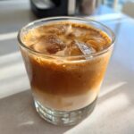 Iced Creamy Baileys Irish Cream Copycat drink in a glass, showing layers of cream and coffee.