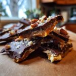 A stack of homemade Holiday Toffee Crunch, featuring chocolate, toffee, and almond pieces.