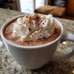 A delicious Homemade Pumpkin Spice Latte topped with whipped cream and a sprinkle of spice.