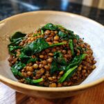 A bowl of hearty lentil stew with spinach, perfect for a comforting meal.