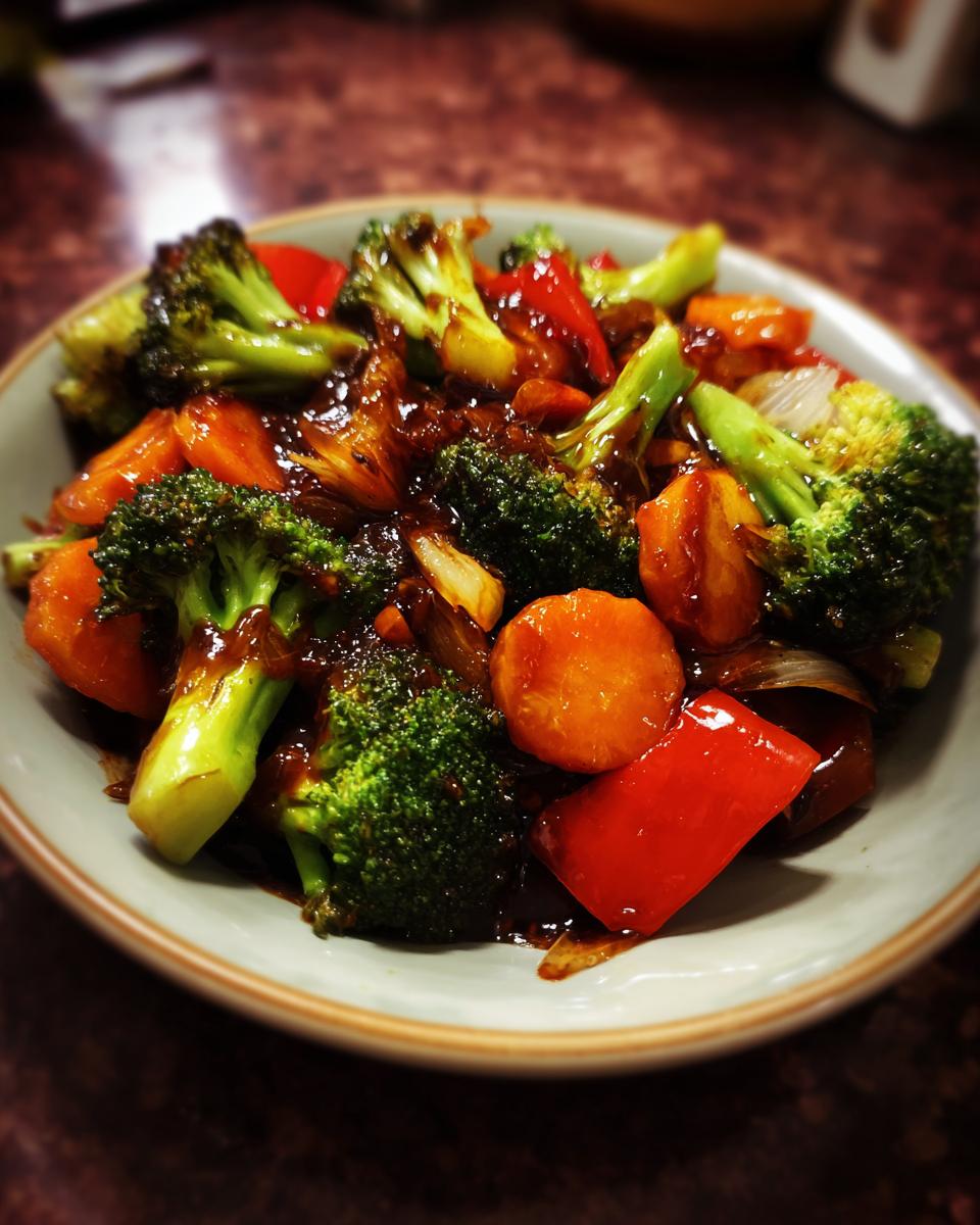 A vibrant bowl of Vegetable Stir Fry featuring broccoli, carrots, and red bell peppers in a savory sauce.