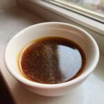 A white bowl filled with rich, homemade au jus, perfect for the Best Homemade Au Jus Recipe.