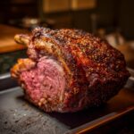 A perfectly cooked prime rib roast with a crispy, seasoned crust and a juicy, pink interior.