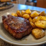 A perfectly cooked steak and golden roasted potatoes served on a plate, showcasing a restaurant-quality Steak & Potatoes meal.