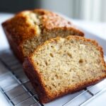 A close-up slice of moist 2-Banana Small-Batch Banana Bread resting on a cooling rack.