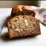 Close-up of a moist slice from the Best Banana Bread Ever, showing walnuts embedded in the crumb.