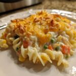 A close-up of a creamy pasta casserole slice topped with melted cheddar cheese, perfect for quick & easy family dinner casseroles.