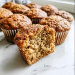 Close-up of a Meal-Prep Banana Bread Muffin cut in half showing the moist, crumbly texture.