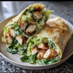 Close-up of two halves of Chicken Caesar Wraps filled with crispy chicken, romaine lettuce, and creamy Caesar dressing.