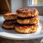 A stack of four golden brown, pan-fried Quick Tuna Patties resting on a white plate.