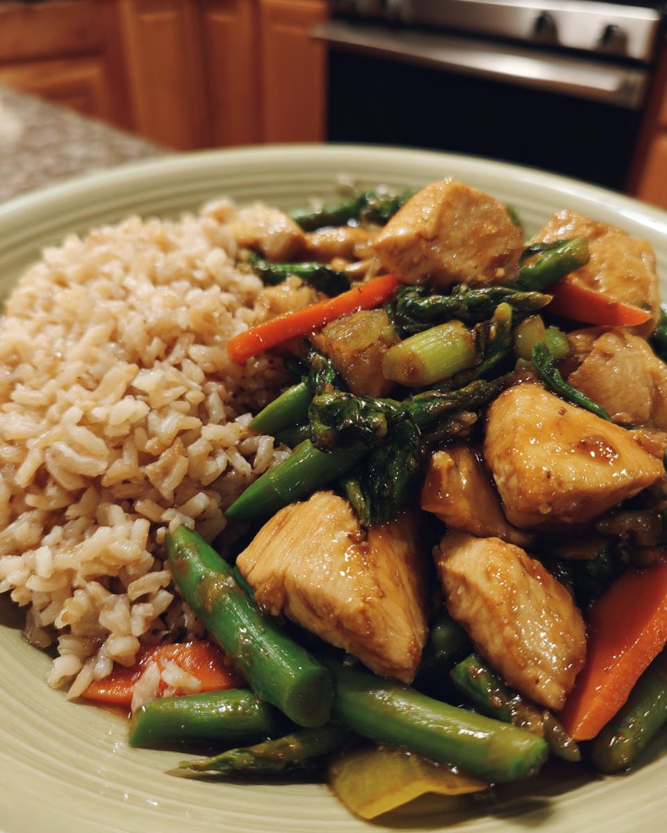 A healthy meal prep bowl featuring chicken and asparagus stir-fry with brown rice, part of Budget-Friendly Healthy Meal Prep Recipes.
