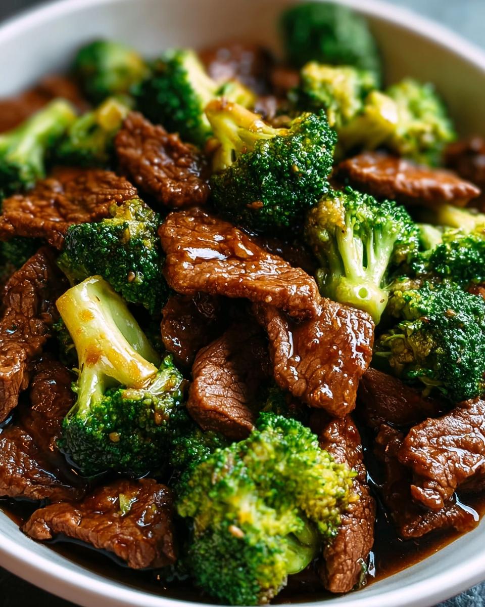 Close-up of tender beef and vibrant broccoli florets coated in a savory sauce, a key component of Chinese Beef and Broccoli.