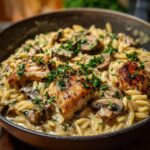 Close-up of a creamy chicken and mushroom orzo dish, garnished with fresh parsley. A perfect weeknight dinner recipe.