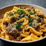 Close-up of creamy one-pot beef pasta with garlic butter, topped with fresh parsley and grated cheese.