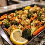 Sheet pan of roasted chicken, broccoli, cauliflower, and carrots, a perfect healthy family dinner.