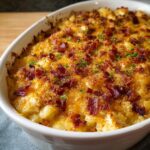 Close-up of a baked Irresistible Crack Chicken Casserole topped with crispy bacon and chives.