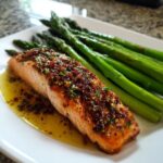A perfectly cooked salmon fillet topped with a savory glaze, served alongside fresh asparagus spears, ideal for light & fresh lunch ideas.