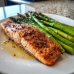 A perfectly cooked salmon fillet served with a side of vibrant green asparagus, a perfect example of quick healthy meals for weight balance.